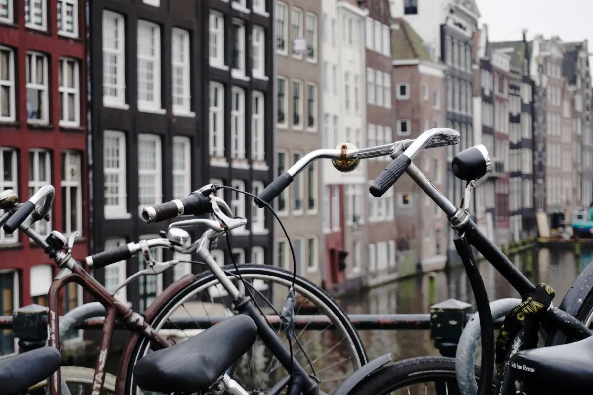 Fietsen tegen een brugleuning boven een gracht.