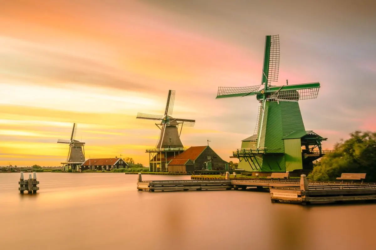 Molens aan het water bij zonsondergang.